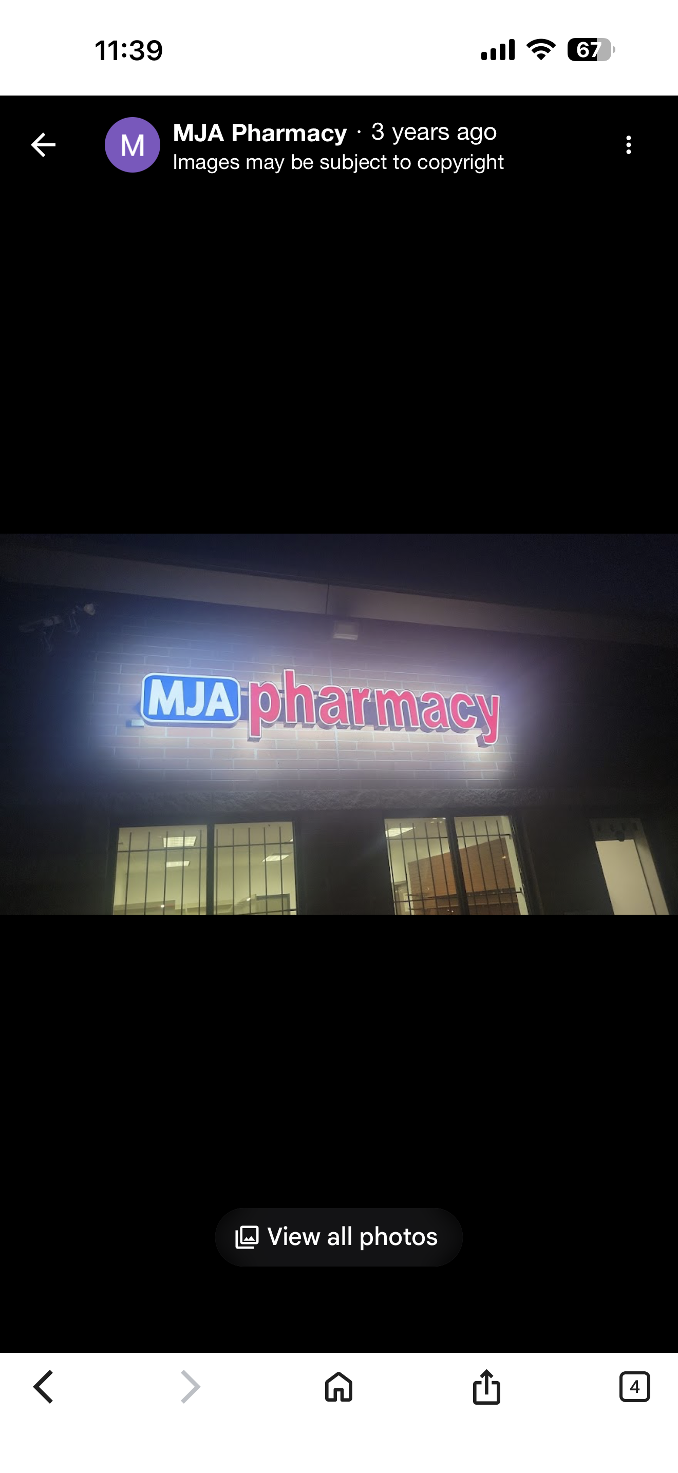 MJA Pharmacy exterior at night with illuminated sign